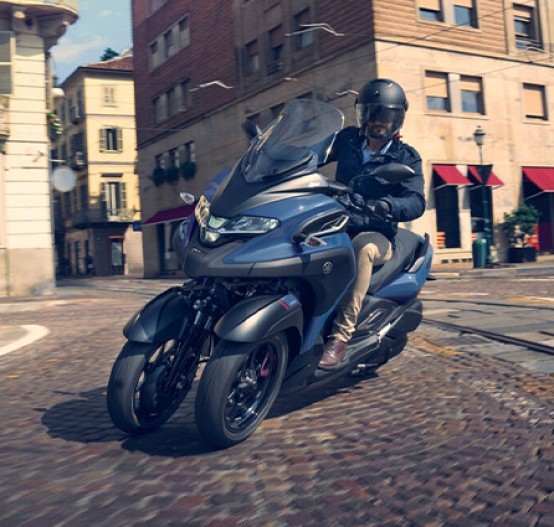 Action image of Yamaha Tricity 300 scooter in blue colourway, entering city intersection