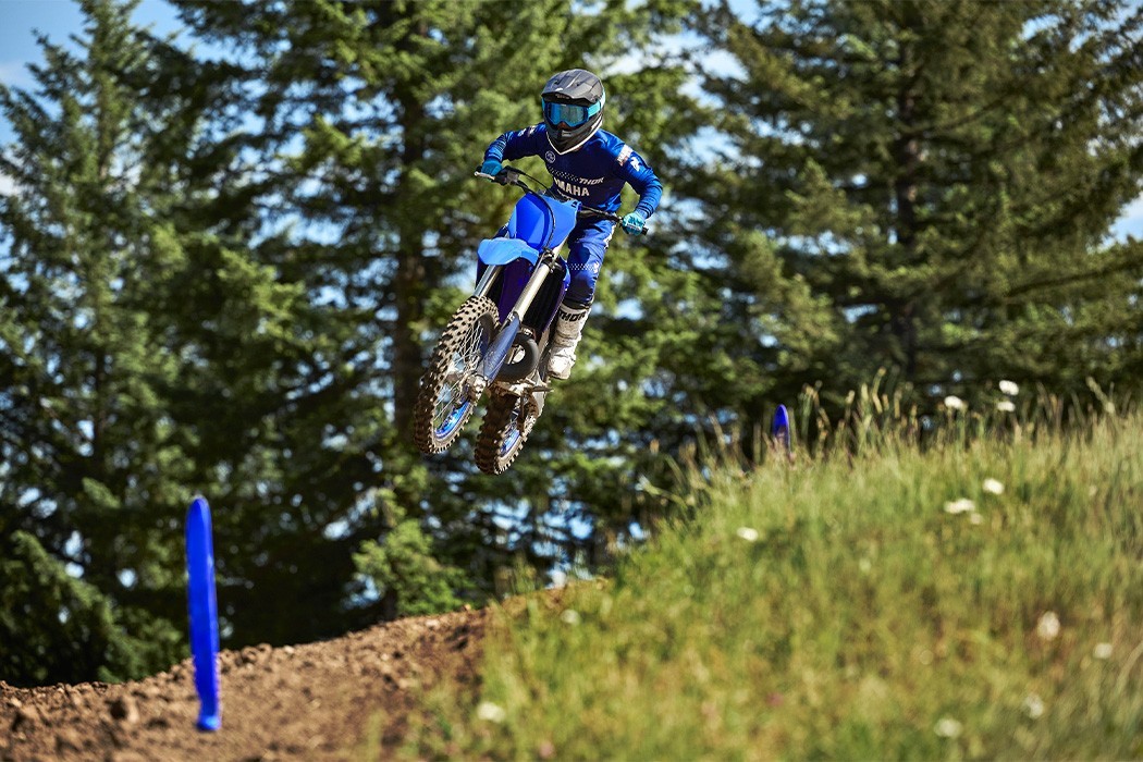 Action image of Yamaha YZ250 two stroke in Blue colourway, rider about to land jump