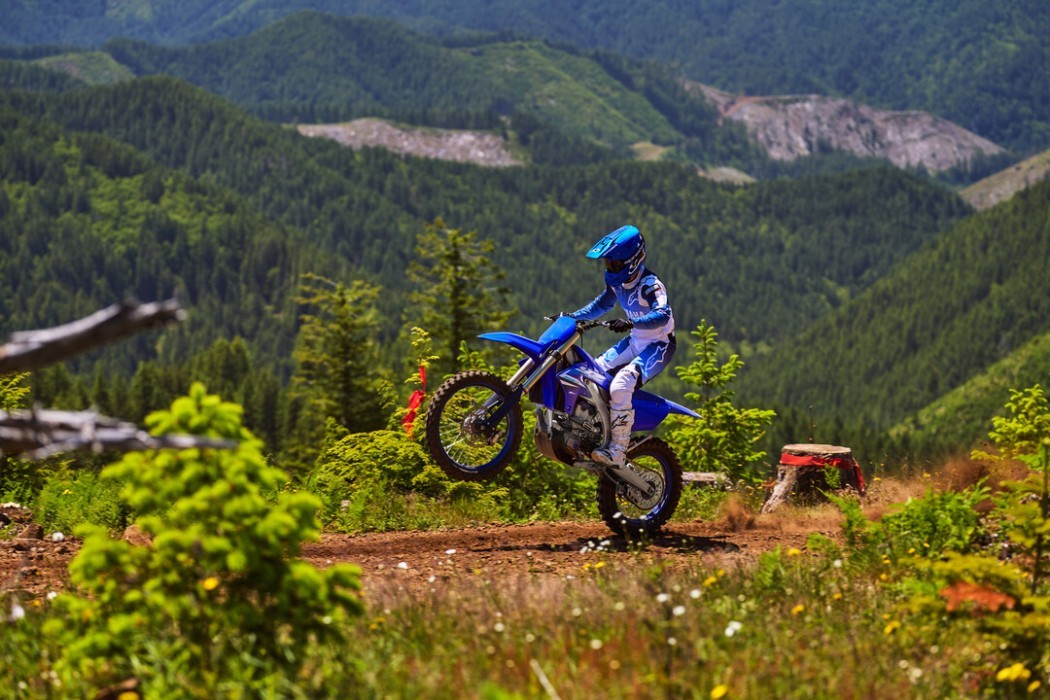 YZ250FX 2025 static image of enduro bike doing wheelie along dirt road