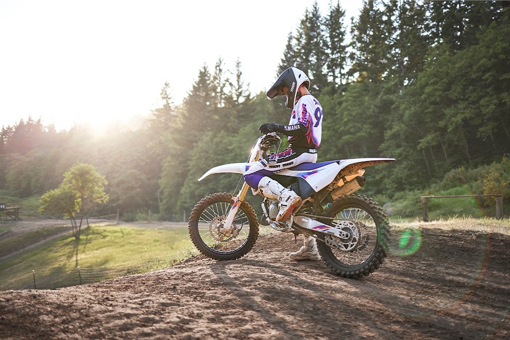 static image of Yamaha YZ125 two stroke in 50th Anniversary colourway, rider sitting on bike at motocross track