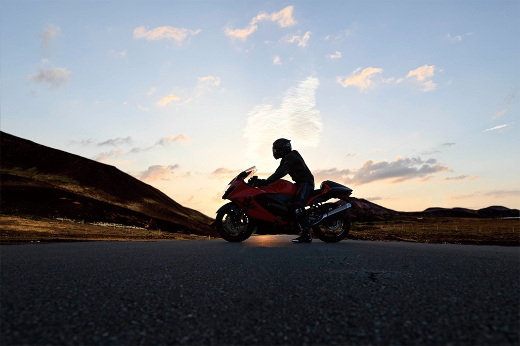 Rider sitting on Hayabusa 25th Anniversary at sunset in middle of road in the mountains
