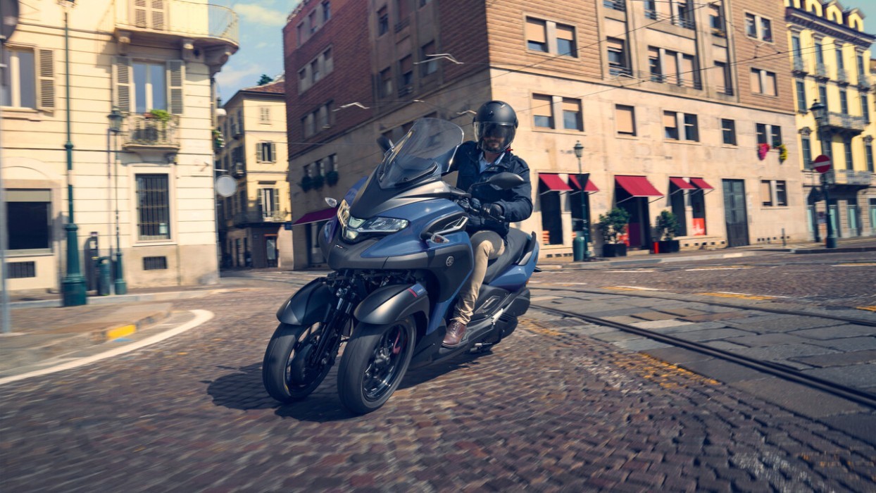 Action image of Yamaha Tricity 300 in blue colourway, turning onto city intersection