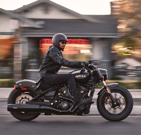 Action image of Indian Scout Bobber 2025 cruiser in Black Smoke Colour, side on tracking through suburb