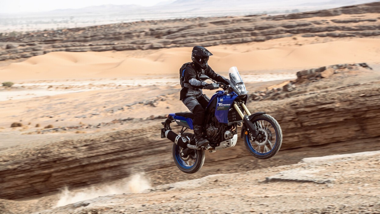 Action image of Yamaha Tenere 700 in Blue Colourway, small jump in desert landscape