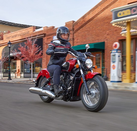 Action image of Indian Scout Classic 2025 cruiser, front three quarter tracking through suburb