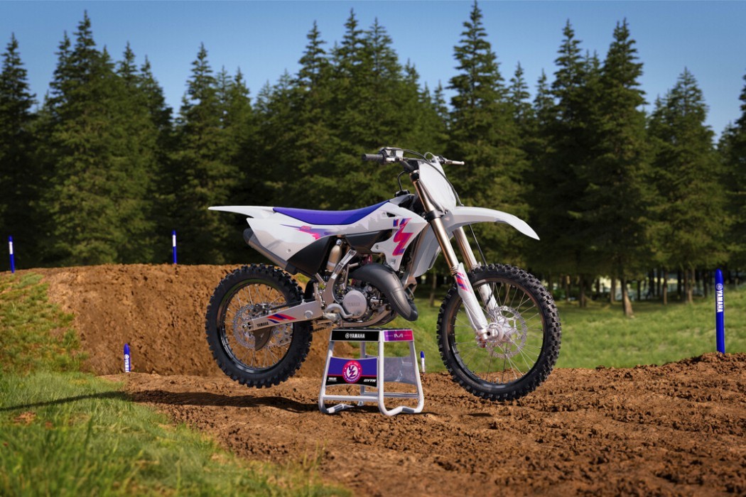 Static image of Yamaha YZ125 two stroke in 50th Anniversary colourway, long shot front three quarter at motocross track