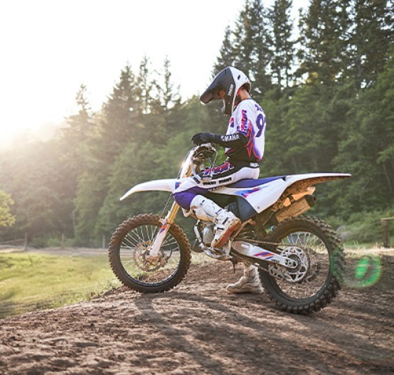 Static image of Yamaha YZ125 two stroke in 50th Anniversary colourway, rider sitting on bike