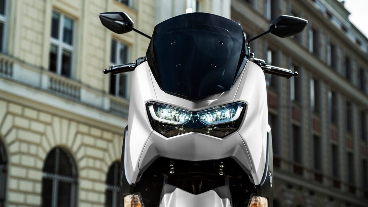 Detail image of Yamaha NMAX 155 scooter in white colourway, front headlights and windscreen