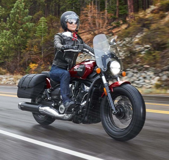 Action image of Indian Super Scout 2025 cruiser, front three quarter tracking through coastal town in wet weather