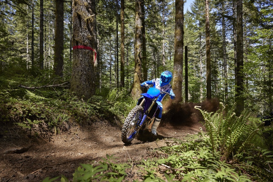 Action image of Yamaha YZ450FX in Blue colourway, sliding through bush track