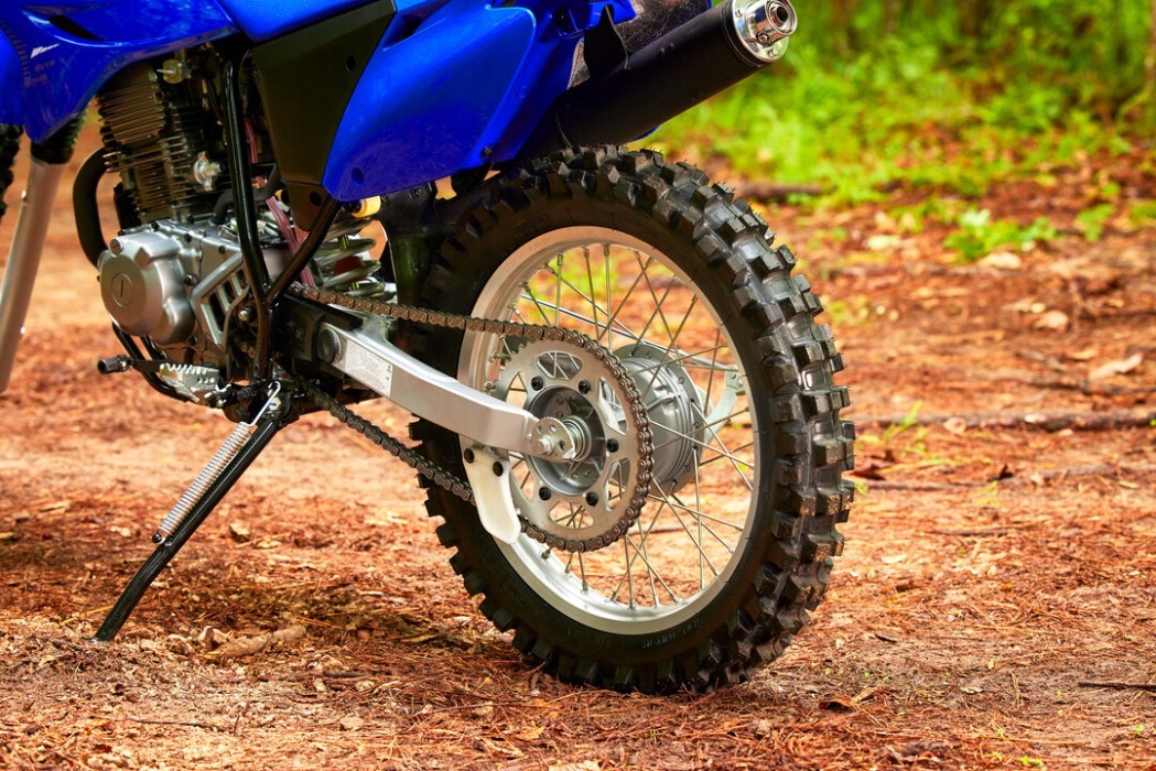 Detail image of Yamaha TT-R230 2023 in Blue colourway, rear wheel, chain and sprockets, suspension and exhaust