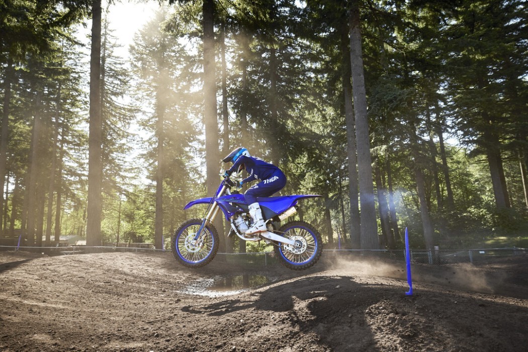 Action image of Yamaha YZ125 two stroke in Blue colourway, side on over small jump
