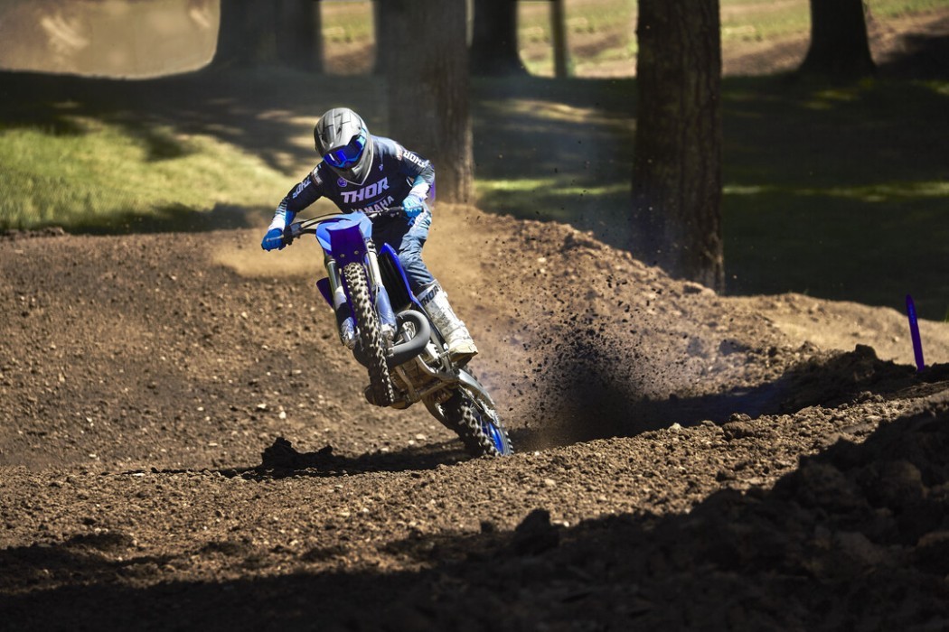Action image of Yamaha YZ250 two stroke in Blue colourway, wheelie out of berm